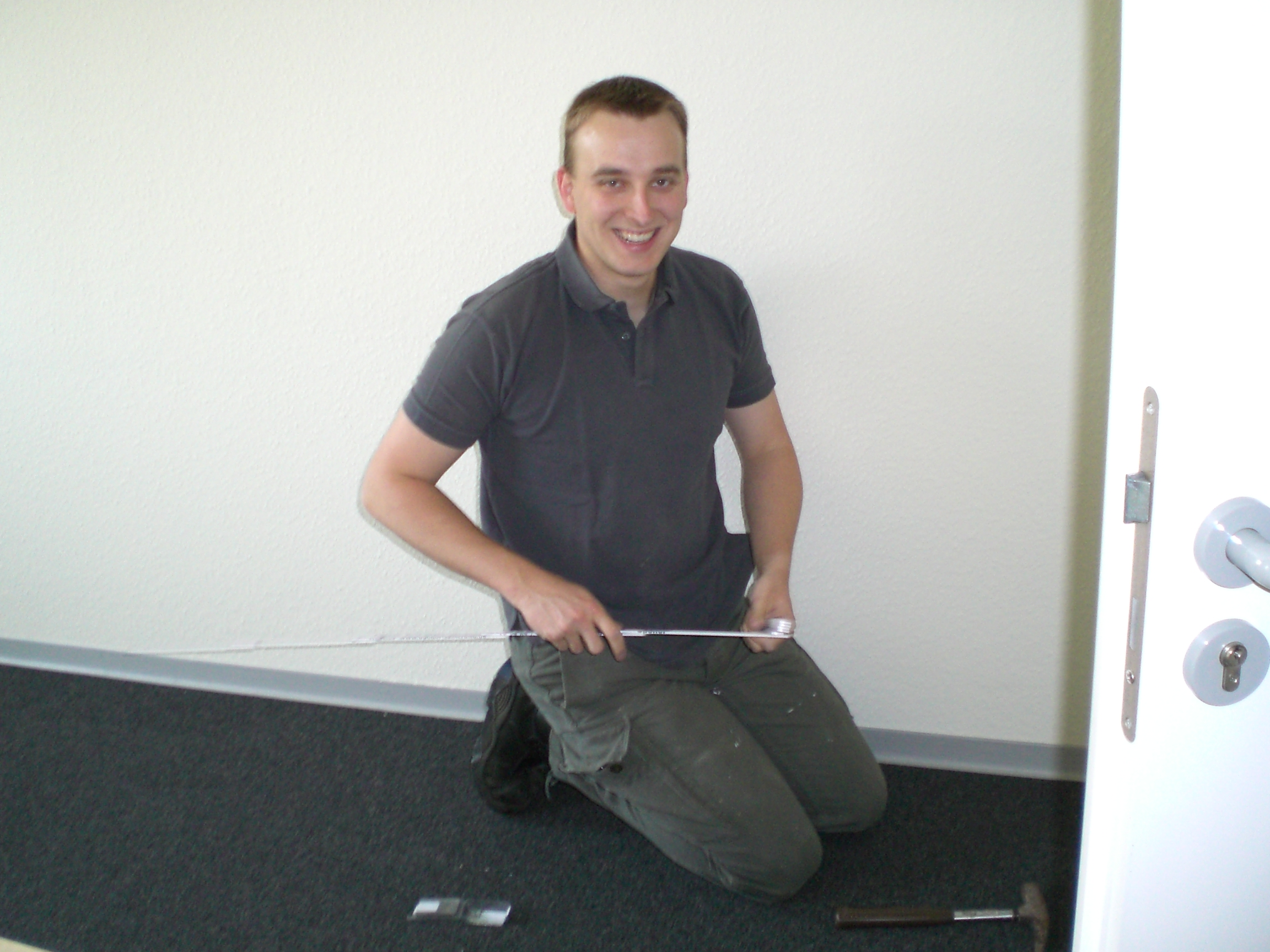 Gründer als Handwerker Verlegen des Teppichbodens im StartUp